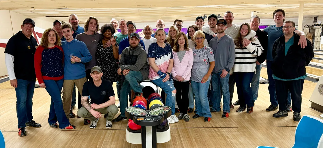 Large group of food service professionals and distributors gathered at a bowling alley for team building and networking event.